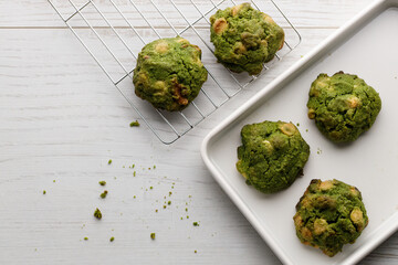 Closeup of fresh baked matcha cookies on white wooden background.