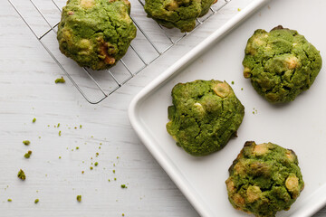 Closeup of fresh baked matcha cookies on white wooden background.
