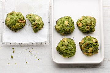 Closeup of fresh baked matcha cookies on white wooden background.