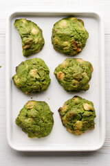 Closeup of fresh baked matcha cookies on white wooden background.