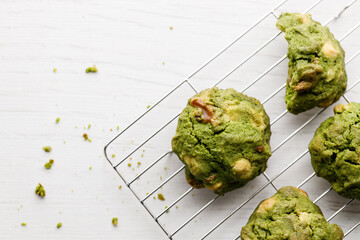 Closeup of fresh baked matcha cookies on white wooden background.