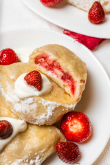 Homemade dumplings with strawberry filling and a dollop of sour cream. Excellent for advertisements, websites, or editorial use in culinary topics.