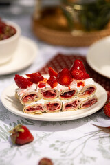 Strawberry crepe cake under garden shade. Sweet dessert for relaxed summer outdoor meal.
