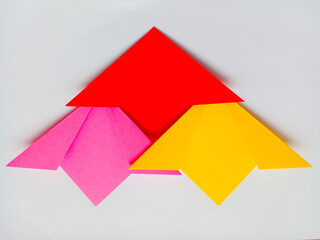 Origami pink, red and yellow flowers isolated on white background.