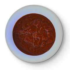 A deep red sauce served in a round white plate, likely used for dipping or as a condiment.