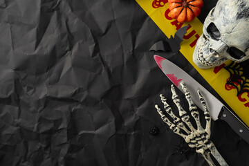 Creepy scene featuring Halloween decorations, including a skull, skeleton hand, bloody knife, and...