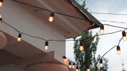 Cafe exterior with decorative light garlands creating cozy street mood