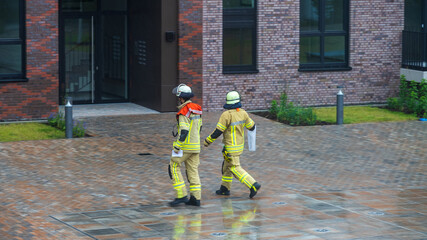 Two firefighters walking in front of modern building