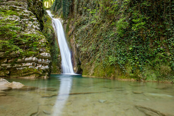 Fototapeta premium A waterfall is flowing into a small pool of water