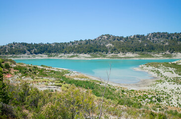 Apolakkia dam lake in Rhodes in Greece. Beautiful blue color Apolakkia Reservoir lake between mountains and forest.