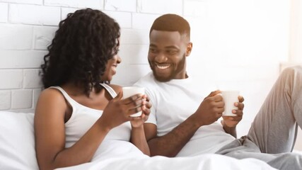 A happy couple enjoys a morning coffee in bed - Powered by Adobe