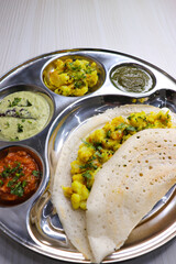 Crispy Masala dosa is a popular South Indian food item served with tomato chutney, coconut chutney, spicy potato masala, or aloo ki sabzi and sambar. Copy space. Crunchy Rice crepes.