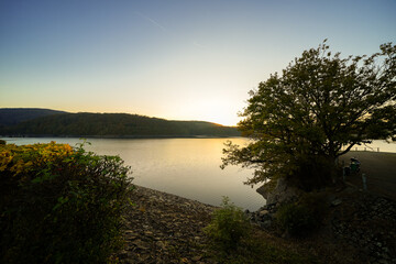 View of the Rursee at the dam near Heimbach-Schwammenauel. Landscape at the lake at sunset. Nature in the Eifel National Park.
