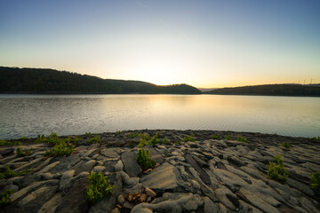 View of the Rursee at the dam near Heimbach-Schwammenauel. Landscape at the lake at sunset. Nature in the Eifel National Park.
