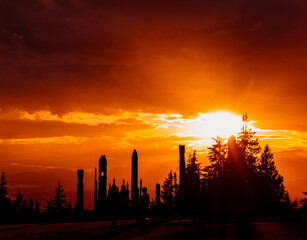 Spectacular sunset view over silhouettes of tall structures and trees at a scenic location