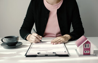 Beautiful real estate agent signs documents and gives home insurance advice Create a home purchase...