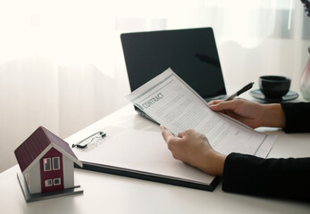 Beautiful real estate agent signs documents and gives home insurance advice Create a home purchase...