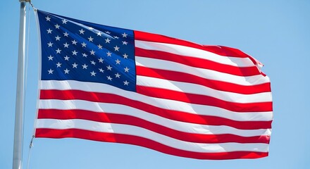 Fototapeta premium Bright American flag proudly waving against a clear blue sky, capturing the essence of patriotism, freedom, and national pride, perfect for holiday and celebratory themes