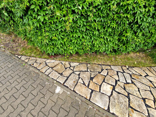 natural paving of flat stones in the shape of an arch. natural terrace near the house. cracks...