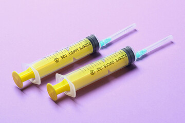 Top view of different syringes for injection on colorful background. Medical equipment concept with...