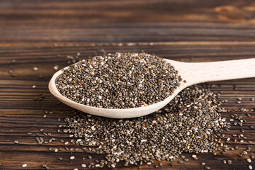 Wooden spoon and chia seeds on colored background, top view. Healthy Salvia hispanica Healthy superfood