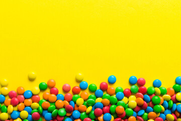 Mixed collection of colorful candy, on colored background. Flat lay, top view. frame of colorful chocolate coated candy