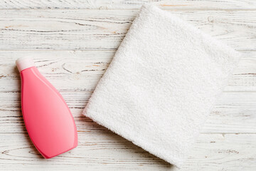 Cosmetic shampoo bottle mockup with towels on a colored table. Bathroom background, toilet...