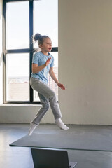 Child enjoys exercise routine in modern indoor space during afternoon.