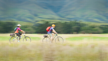 Panning shot capturing motion on the cycling trail. Couple cycling Otago Central Rail Trail. South...