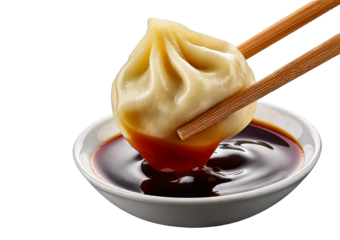 Delicious dumpling held with chopsticks, dripping soy sauce isolated on a transparent or white background