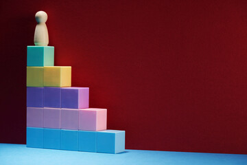 wood figurine  on top of colorful toy blocks