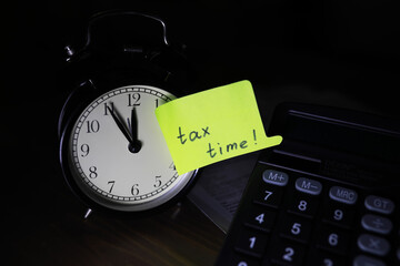 Tax Time Reminder with Alarm Clock and Calculator in Dark Background