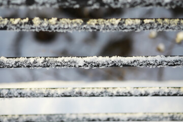 Snow-Covered Metal Bars: Winter Frost and Snowflakes Creating Natural Patterns