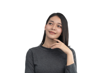 Thoughtful woman with braces smiling while looking upwards in a grey sweater against a transparent background expressing joy and contemplation
