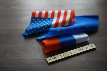 International Sanctions Concept with USA, EU, and Russia Flags on Wooden Table