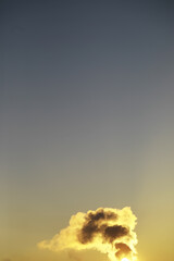 Bright Sunset Sky with Silhouette of Smoke Cloud Rising from the Horizon