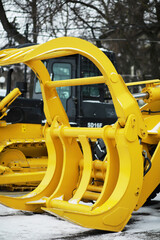 Yellow Logging Machine Attachment on Snowy Day in Industrial Setting