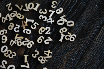 Scattered Wooden Numbers on Dark Wooden Background for Educational and Creative Use