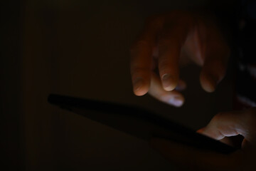 Close-up of Hands Using Tablet in Dim Lighting for Work or Study at Night