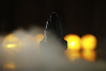 Mysterious Hooded Figure in Dim Light with Bokeh Background © alexkich