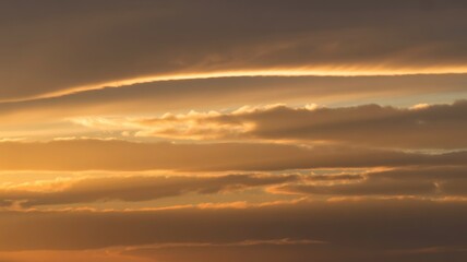 Fototapeta premium Golden sunset sky with layers of clouds and warm light