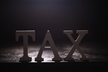 Illuminated Tax Sign in Dark Background - Financial Concept and Accounting Symbol