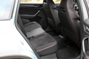 Sport car seats. Sport car interior. The rear seat of a luxury sports SUV with diamonds and red stitching. The interior of the new car is made of black alcantara with red stitching.