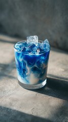 a glass of iced blue latte, marble-like swirl of blue and white milk