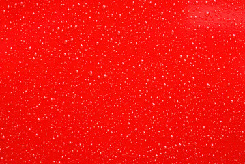 Red Surface with Shiny Water Droplets in Close-Up