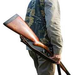 Mature man hunter with gun while walking on field.