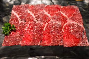 Premium rare slice of raw beef meat. Fresh cut of beef meat on black board