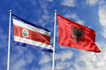 3D illustration. Costa Rica and Albania flags waving in the sky. High detailed waving flag. 3D render. Flags fluttered in the cloudy sky, symbolizing diplomatic relations.