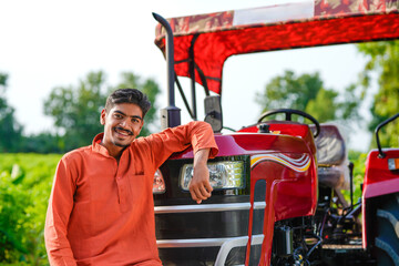 indian farmer standing with tractor at field