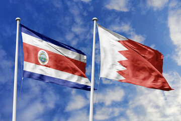 3D illustration. Costa Rica and Bahrain flags waving in the sky. High detailed waving flag. 3D render. Flags fluttered in the cloudy sky, symbolizing diplomatic relations.
